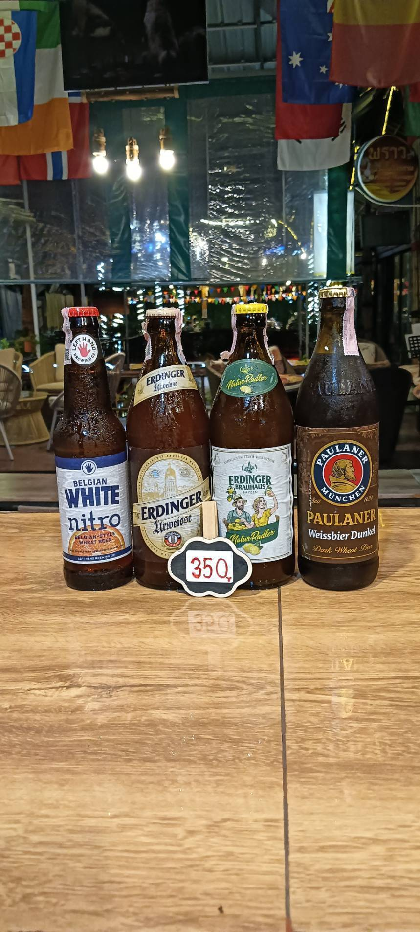 Left Hand Belgian White Nitro, Erdinger Urweisse, Erdinger Natur Radler and Paulaner Weissbier Dunkel bottles, priced at 350 baht